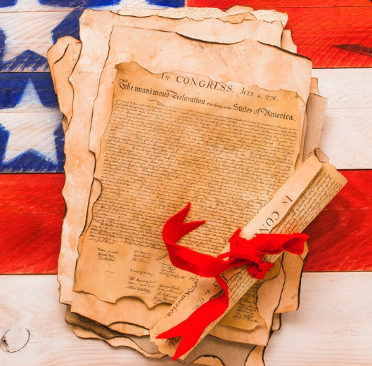us declaration of indepence in front of us flag
