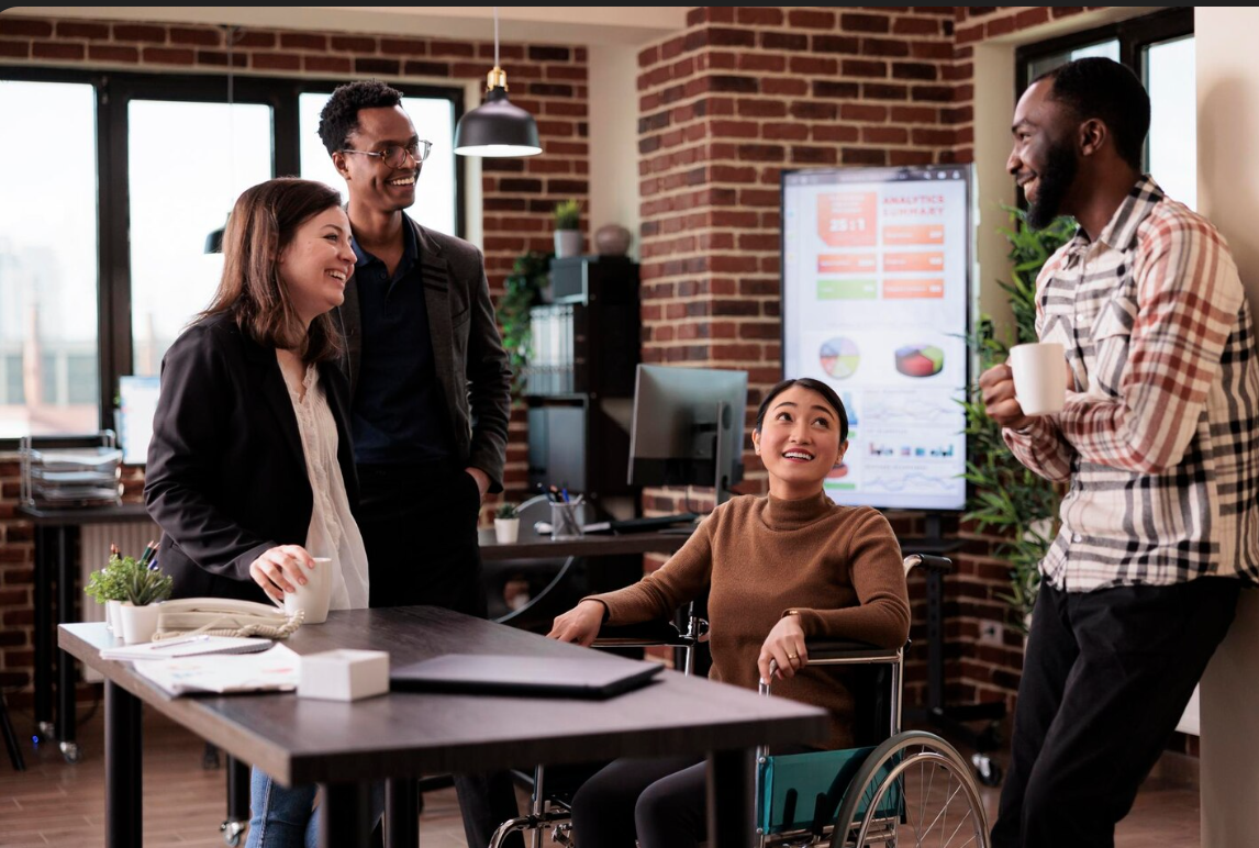 diverse group chatting, one in wheelchair one with hearing aid