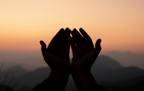 open hands pray at dawn on mountain