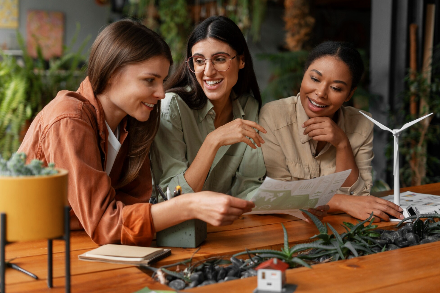 three women: Latina, African and Caucasian decent agreeing in meeting in sustainable lab