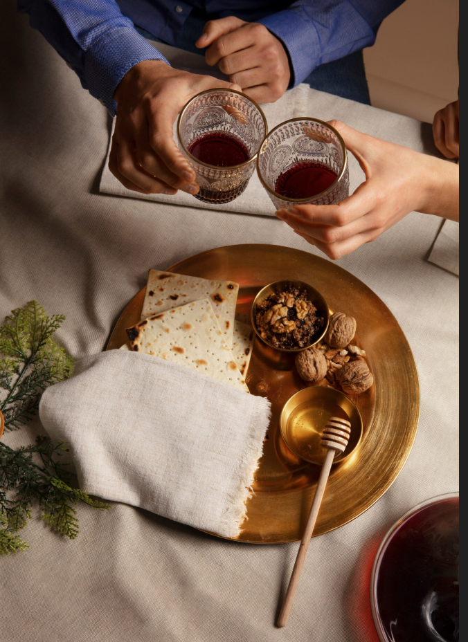 glasses clink over matzah plate with honey